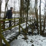 Verschneite Brücke über einem Bach